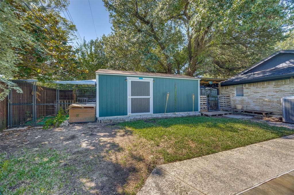 6401 Stonewall Street, Greenville, TX 75402 Backyard featuring a detached storage shed, privacy fencing, and a concrete walkway