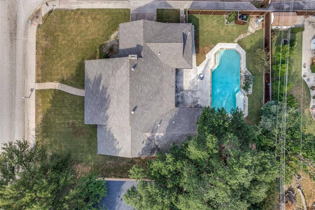 6401 Stonewall Street, Greenville, TX 75402 Attached pool with surrounding patio, mature trees, and fenced backyard