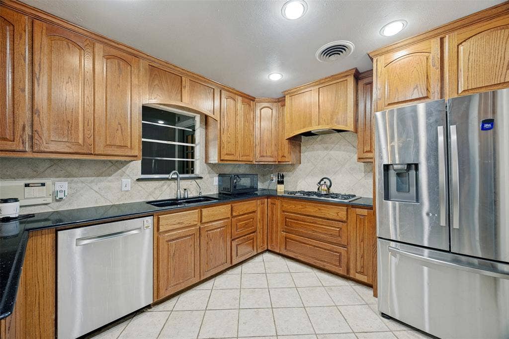 6401 Stonewall Street, Greenville, TX 75402 Wood-finish cabinetry with dark countertops