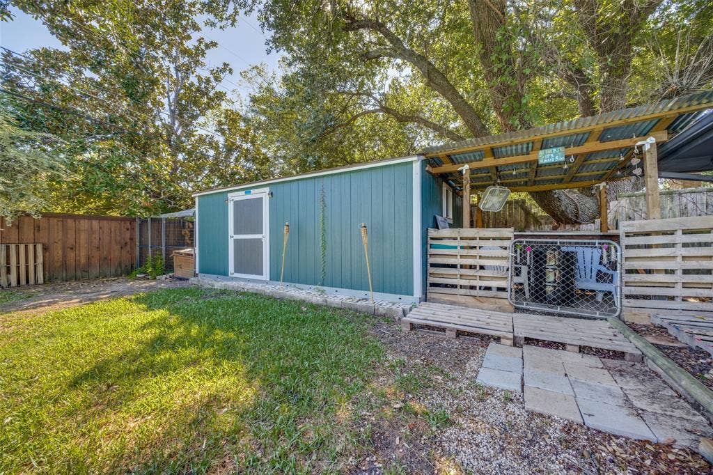 6401 Stonewall Street, Greenville, TX 75402 Backyard featuring a shed with a covered patio area, wood fencing, and mature trees