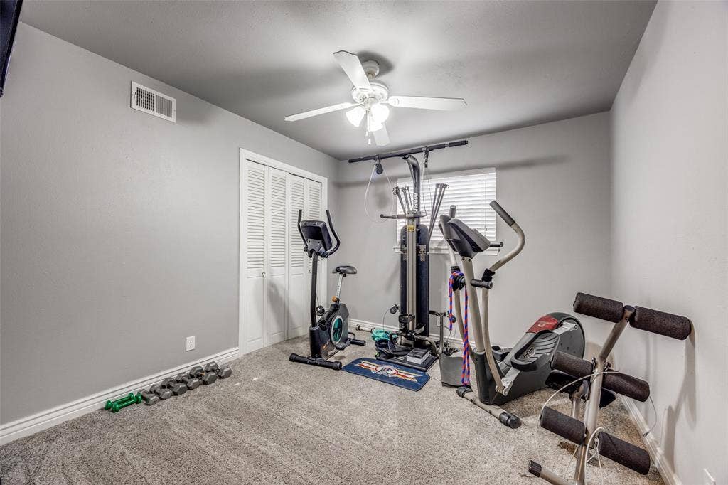 6401 Stonewall Street, Greenville, TX 75402 Carpeted room featuring a ceiling fan, window with blinds, and bi-fold closet doors