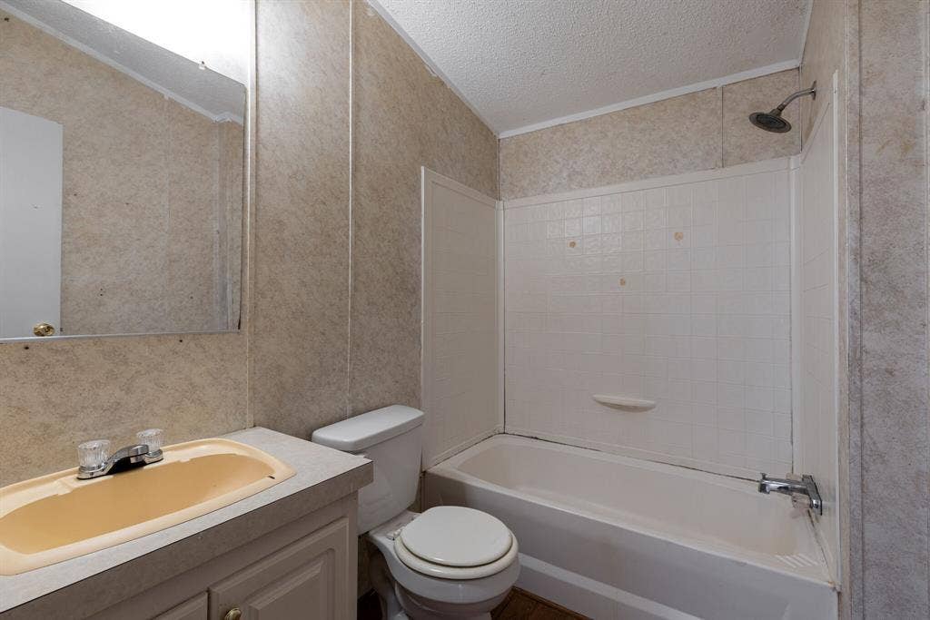 143 Summit Ridge Lane, Springtown, TX 76082 Bathroom featuring a vanity with an integrated sink, a toilet, and a combined shower-tub unit