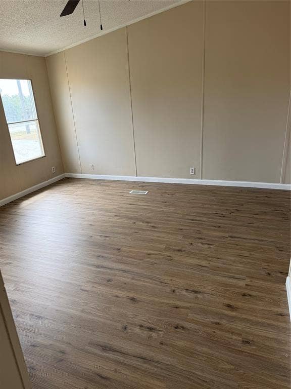 143 Summit Ridge Lane, Springtown, TX 76082 Wood-finish flooring with neutral wall paneling, vaulted ceiling, and a ceiling fan