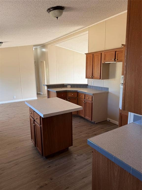 143 Summit Ridge Lane, Springtown, TX 76082 Kitchen featuring wood-finish cabinetry, solid surface countertops, and a central island