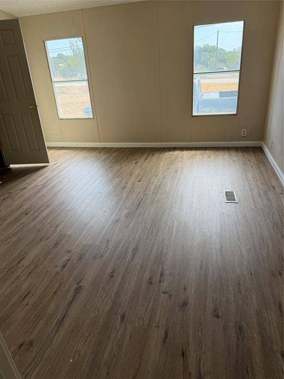 143 Summit Ridge Lane, Springtown, TX 76082 Spacious room flooded with natural light through dual windows, featuring wood-finish plank flooring and neutral wall finishes