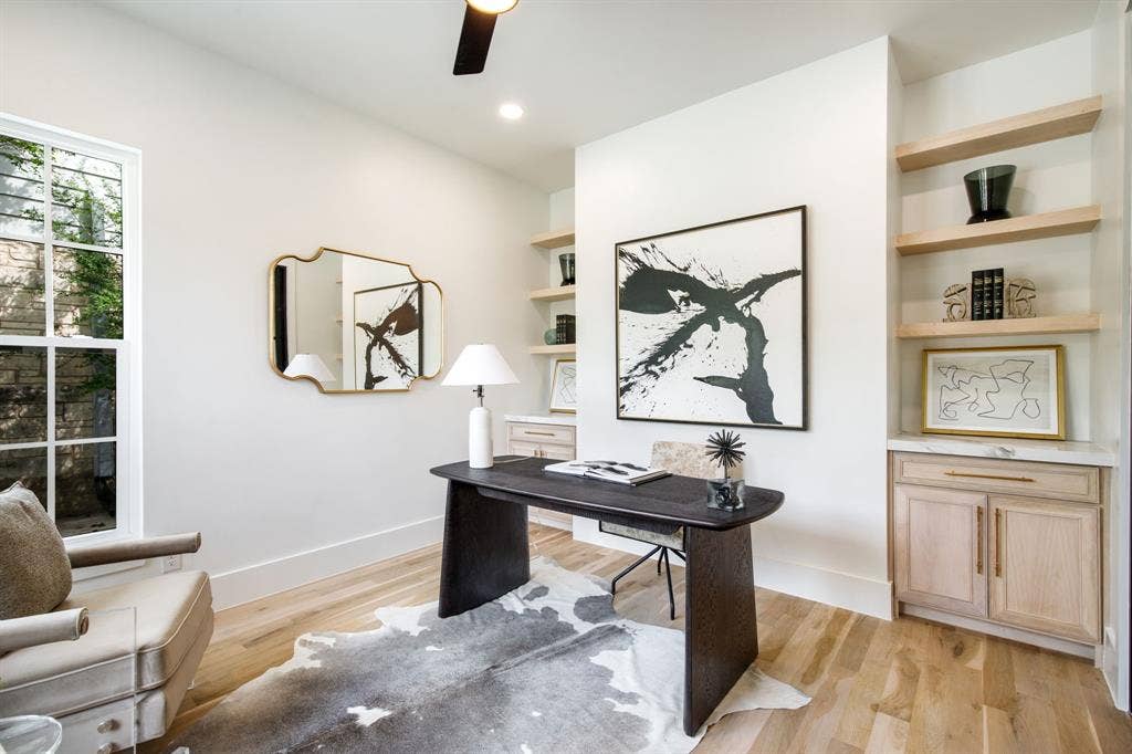 Wood-finish flooring, recessed lighting, built-in shelving, built-in cabinetry with marble-look countertop, and a window with grid panes