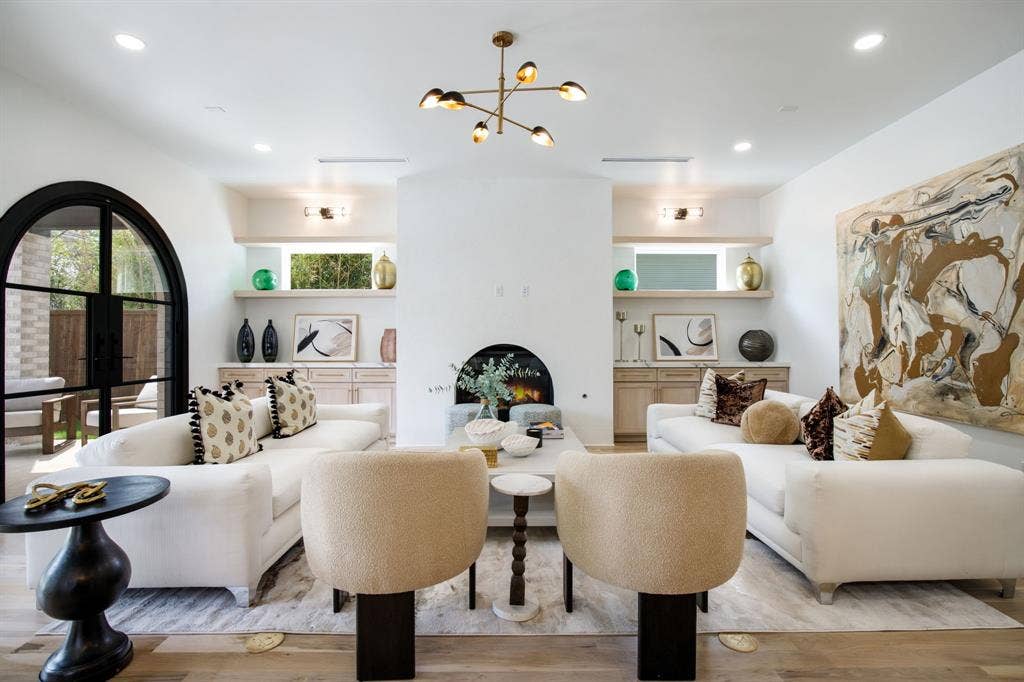 Recessed lighting, wood-finish flooring, and a central fireplace with an arched opening