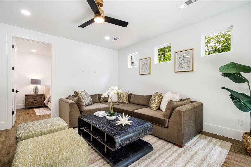 Recessed lighting, wood-finish flooring, and a modern ceiling fan with a gold-tone accent