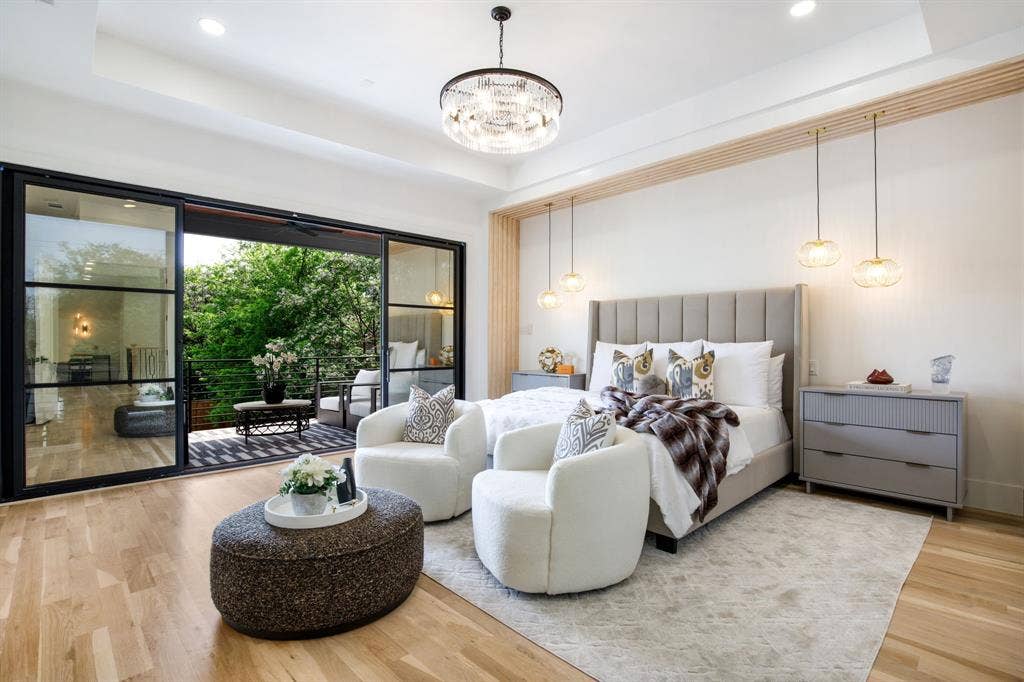 Hardwood flooring, recessed lighting, and a chandelier illuminate this interior space