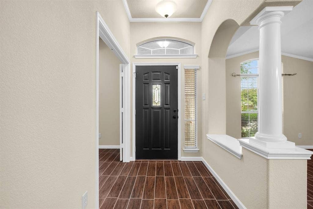 10108 Parker Springs Drive, Waco, TX 76708 Entryway featuring wood-finish tile flooring, a dark paneled door with decorative glass, and an arched doorway