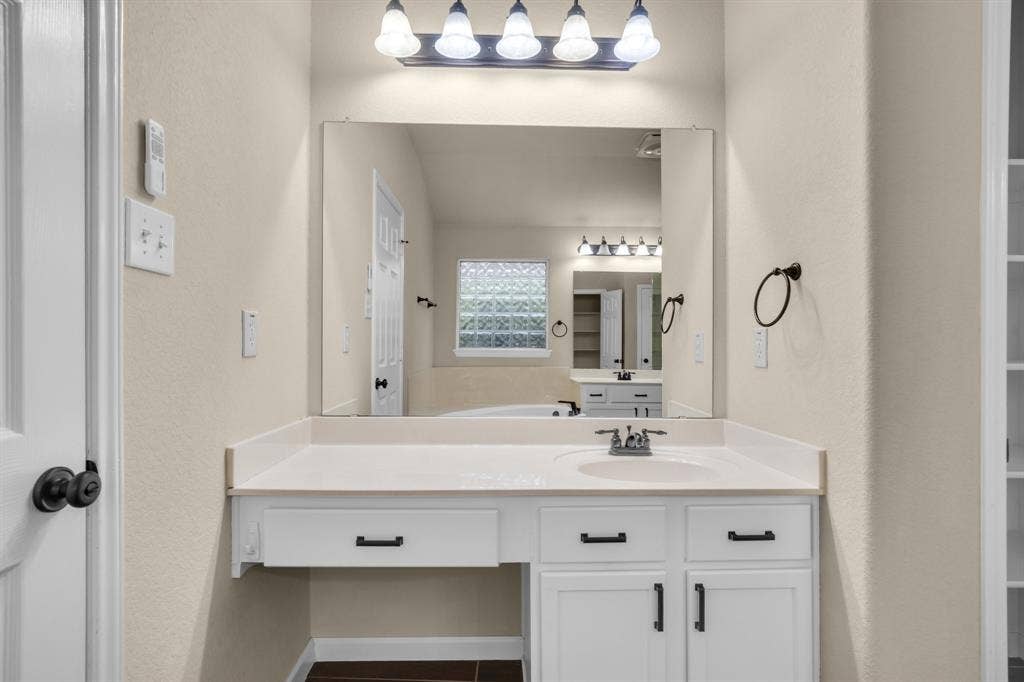 10108 Parker Springs Drive, Waco, TX 76708 Vanity with integrated sink, white cabinetry, and matte black hardware