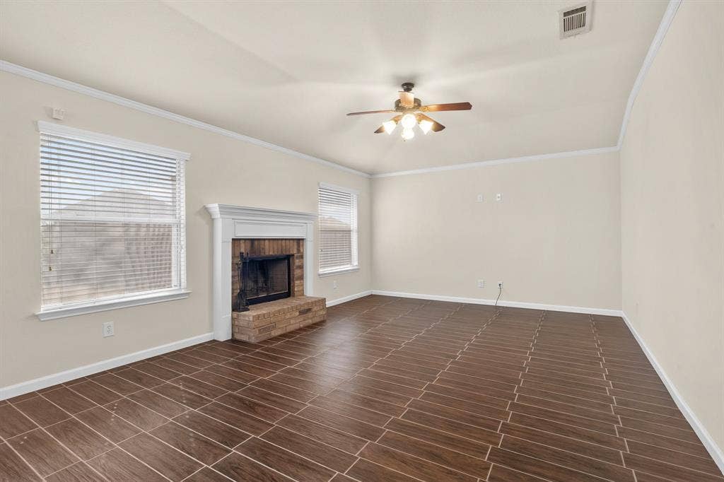 10108 Parker Springs Drive, Waco, TX 76708 Wood-finish tile flooring complemented by a brick fireplace with a classic mantel, ceiling fan, and white trim