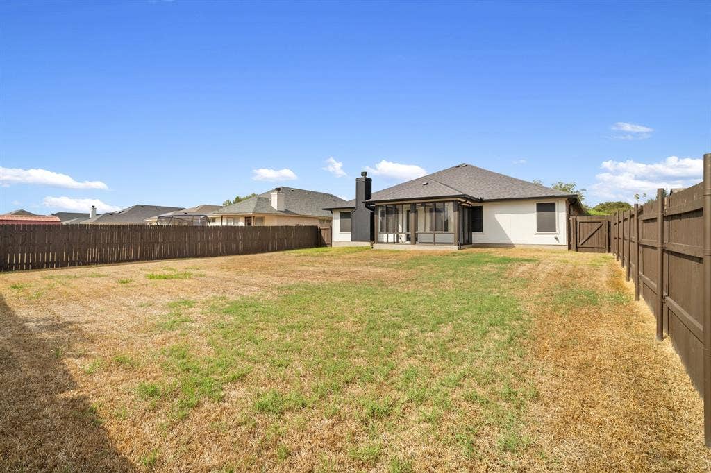 10108 Parker Springs Drive, Waco, TX 76708 Expansive backyard featuring a screened-in patio, wood fencing, and a side gate