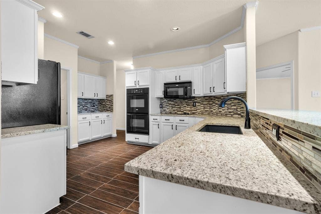 10108 Parker Springs Drive, Waco, TX 76708 Kitchen featuring white cabinetry, built-in double ovens, dark wood-finish tile flooring, granite countertops, and a tile backsplash