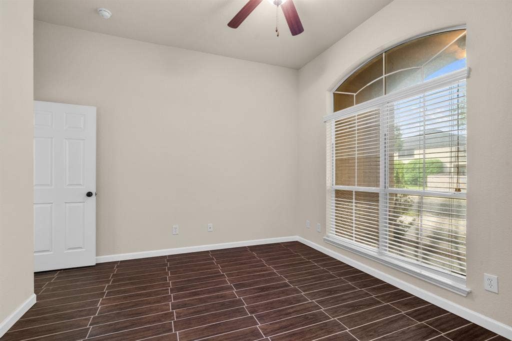 10108 Parker Springs Drive, Waco, TX 76708 Arch-top window with blinds, wood-finish flooring, ceiling fan with integrated lighting, and a white paneled door