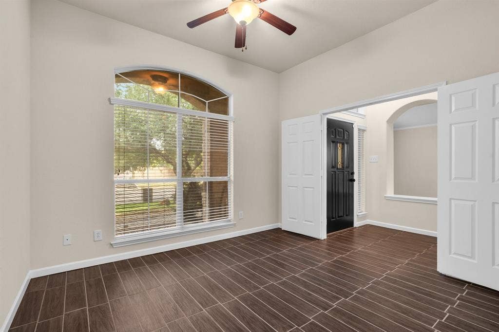 10108 Parker Springs Drive, Waco, TX 76708 Arched window with blinds, wood-finish flooring, ceiling fan, white paneled double doors, and a black front door with decorative glass