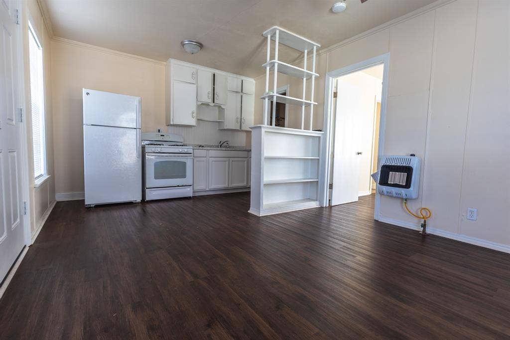 Kitchen featuring white cabinetry, a freestanding range, and a refrigerator