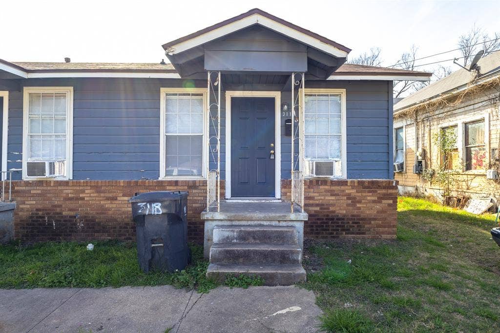 Brick foundation, blue siding, white trim windows, concrete entry steps, covered entry porch