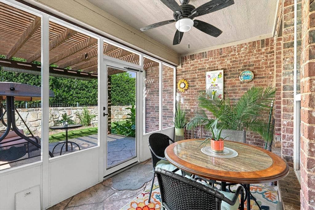 1118 Imperial Valley Lane, Frisco, TX 75036 Enclosed patio featuring a brick accent wall, stone-patterned flooring, and a ceiling fan
