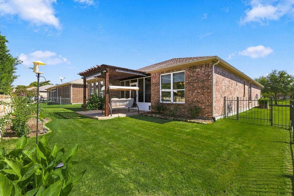 1118 Imperial Valley Lane, Frisco, TX 75036 Brick exterior with a screened patio, wood pergola, and fully fenced backyard