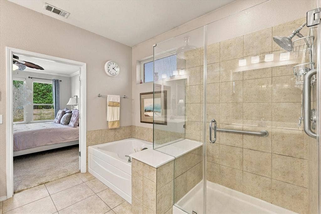 1118 Imperial Valley Lane, Frisco, TX 75036 Primary Bathroom with Walk-in shower with clear glass enclosure and tile surround, accompanied by a built-in glamour tub