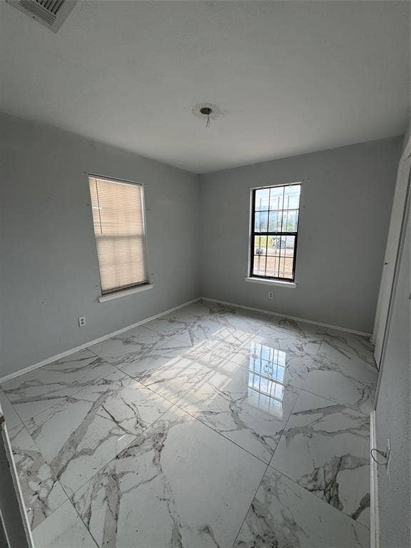 415 E 20th Street, Waco, TX 76705 Spacious room featuring large format tile flooring, two windows, and neutral wall tones