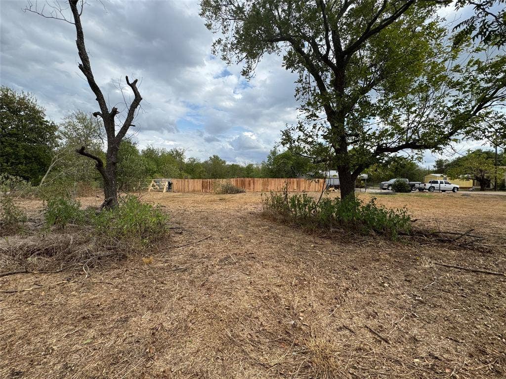 415 E 20th Street, Waco, TX 76705 Cleared lot featuring natural landscaping and a wood privacy fence
