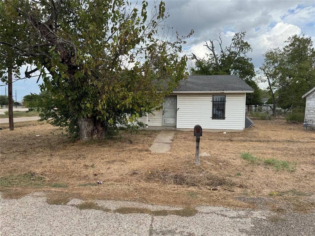 415 E 20th Street, Waco, TX 76705 Charming single-story residence featuring white exterior siding, black-trimmed windows, and a covered front entrance