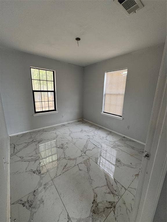 415 E 20th Street, Waco, TX 76705 Polished tile flooring with veining, two windows, and light gray walls