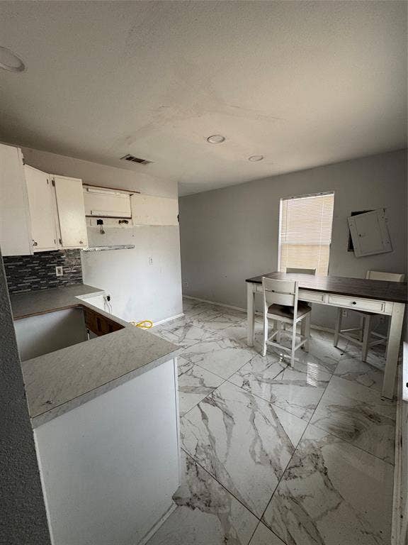 415 E 20th Street, Waco, TX 76705 Kitchenette featuring white cabinetry, grey subway tile backsplash, and light-toned countertops