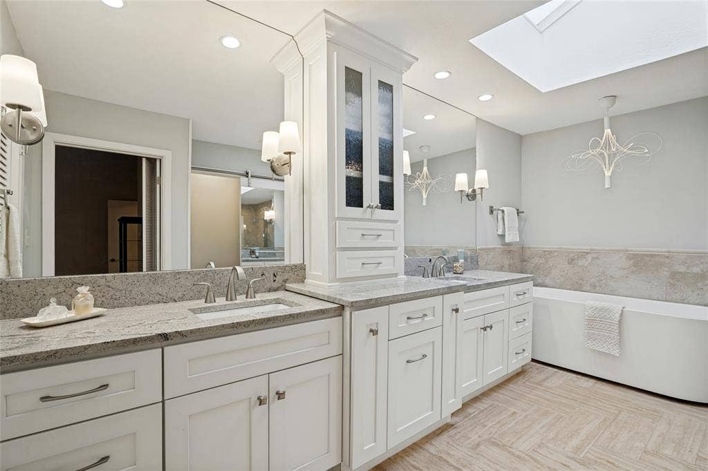 17411 Oakington Court, Dallas, TX 75252 The dream Primary Bath has skylight, separate vanities, vessel tub, and frameless glass shower.