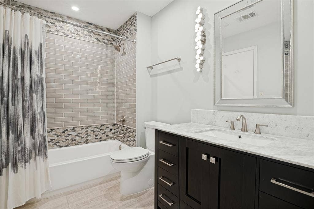 17411 Oakington Court, Dallas, TX 75252 Spacious Bath between Bedrooms 2 & 3 with beautiful vanity cabinet, tile treatments and lighting.