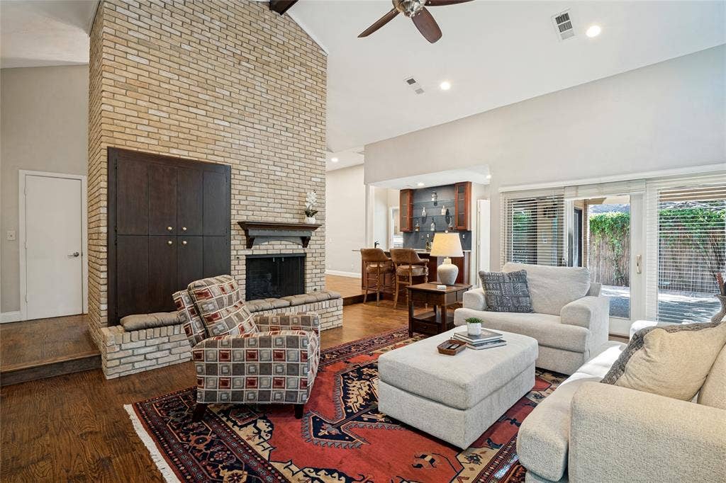 17411 Oakington Court, Dallas, TX 75252 View of the floor-to ceiling fireplace and wet bar and Dining Room beyond.