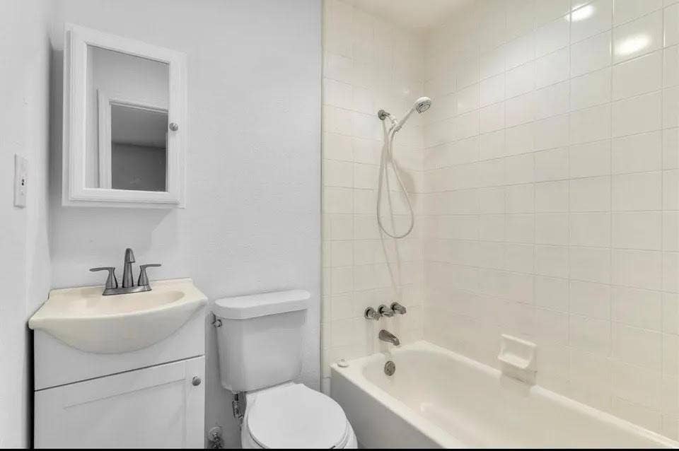 5326 Columbia Avenue, Dallas, TX 75214 Bright bathroom showcasing an alcove tub-shower, toilet and vanity with mirror