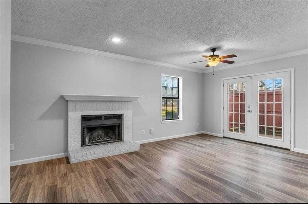 5326 Columbia Avenue, Dallas, TX 75214 A spacious living room featuring a ceiling fan, a fireplace and a glass door, creating a cozy yet open atmosphere.