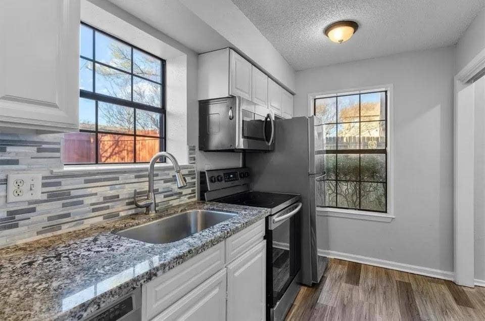 5326 Columbia Avenue, Dallas, TX 75214 Bright kitchen showcasing stainless steel appliances, built-in cabinets and windows to let in natural light.