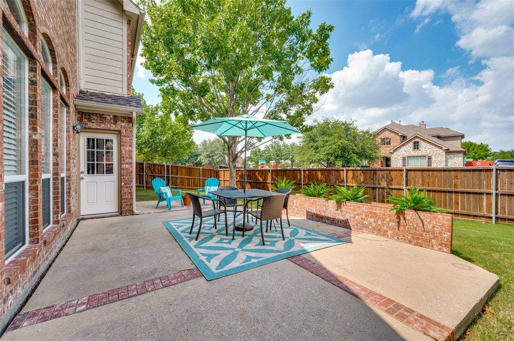 2873 Del Largo Way, Frisco, TX 75033 Expansive concrete patio with brick trim, brick planter boxes, and a wood privacy fence
