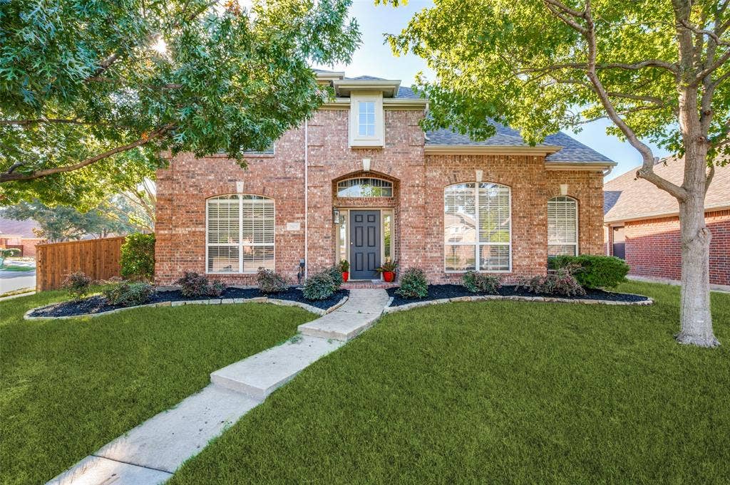 2873 Del Largo Way, Frisco, TX 75033 Brick exterior with arched windows, dark gray front door, and a concrete pathway