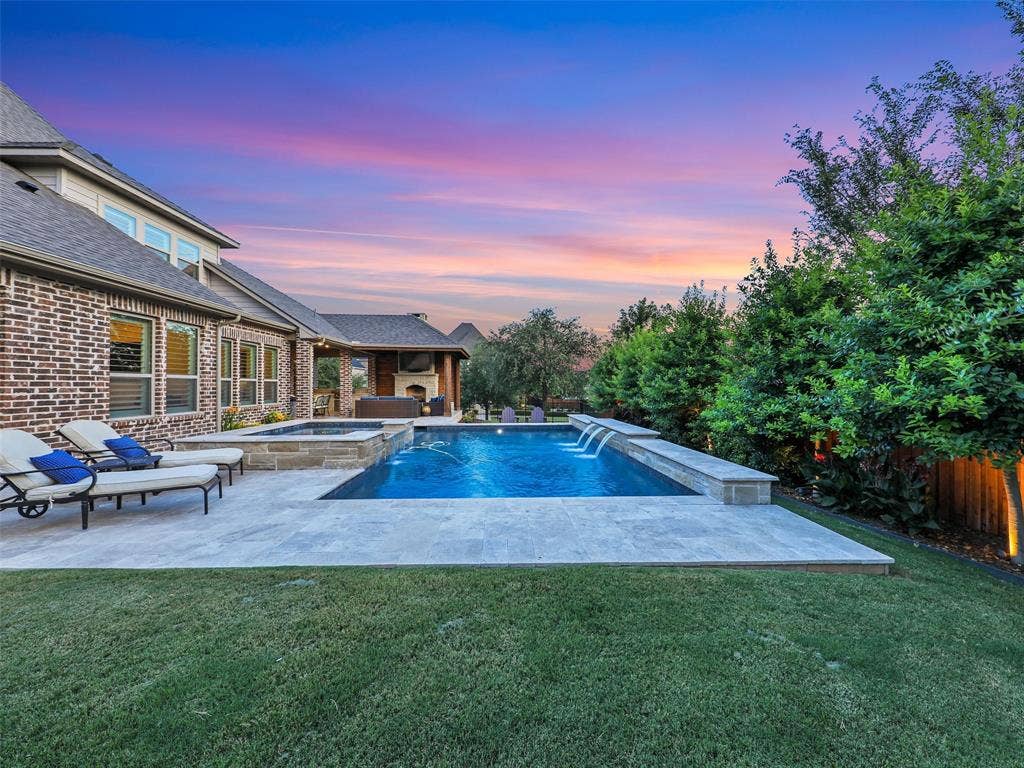 12921 Railhead Court, Frisco, TX 75033 HUGE OPEN YARD SPACE. Outside, the property transforms into a private resort designed for year-round enjoyment. The Foley Pools swimming pool, completed in 2021, is complemented by an oversized spa with seating for approximately 10. Travertine limestone surrounds the pool and is used throughout the decking and coping, giving the outdoor environment a cohesive, upscale finish. Pentair pool equipment with wireless controls provides convenient operation, while individual pumps for the pool features allow greater flexibility and independent control.