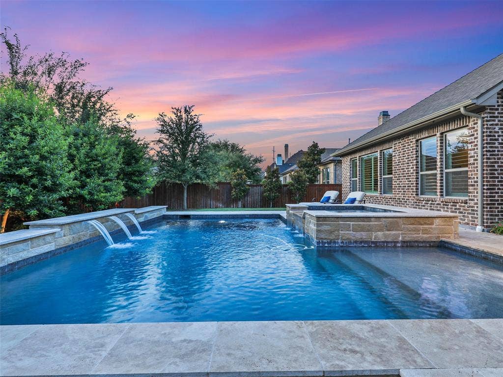 12921 Railhead Court, Frisco, TX 75033 Outside, the property transforms into a private resort designed for year-round enjoyment. The Foley Pools swimming pool, completed in 2021, is complemented by an oversized spa with seating for approximately 10. Travertine limestone surrounds the pool and is used throughout the decking and coping, giving the outdoor environment a cohesive, upscale finish. Pentair pool equipment with wireless controls provides convenient operation, while individual pumps for the pool features allow greater flexibility and independent control.