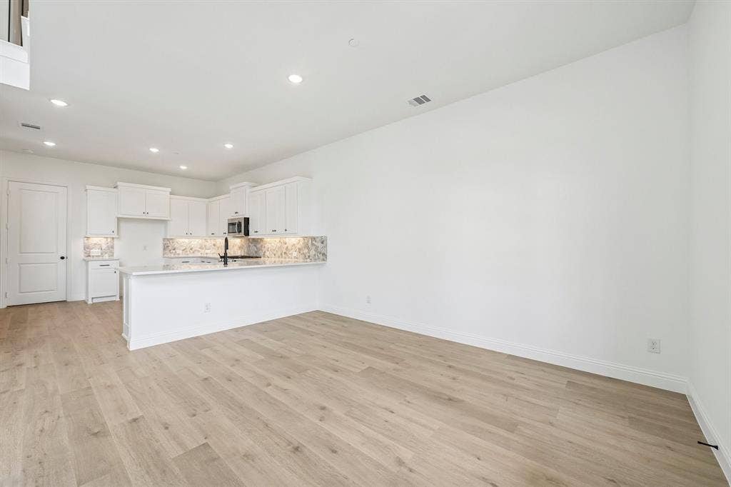 1374 Marsh Lane, Frisco, TX 75033 The kitchen features a spacious peninsula creating additional counter space and a breakfast bar.
