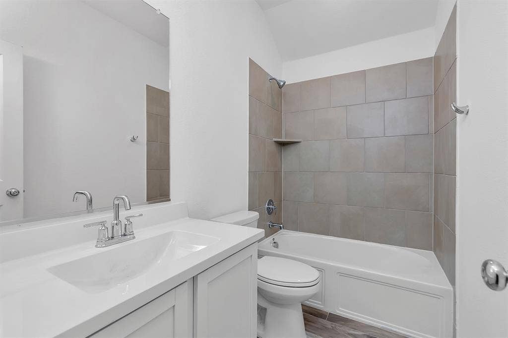 7204 Black Cherry Lane, McKinney, TX 75071 Full bathroom with vanity, shower / bathtub combination, and wood finished floors