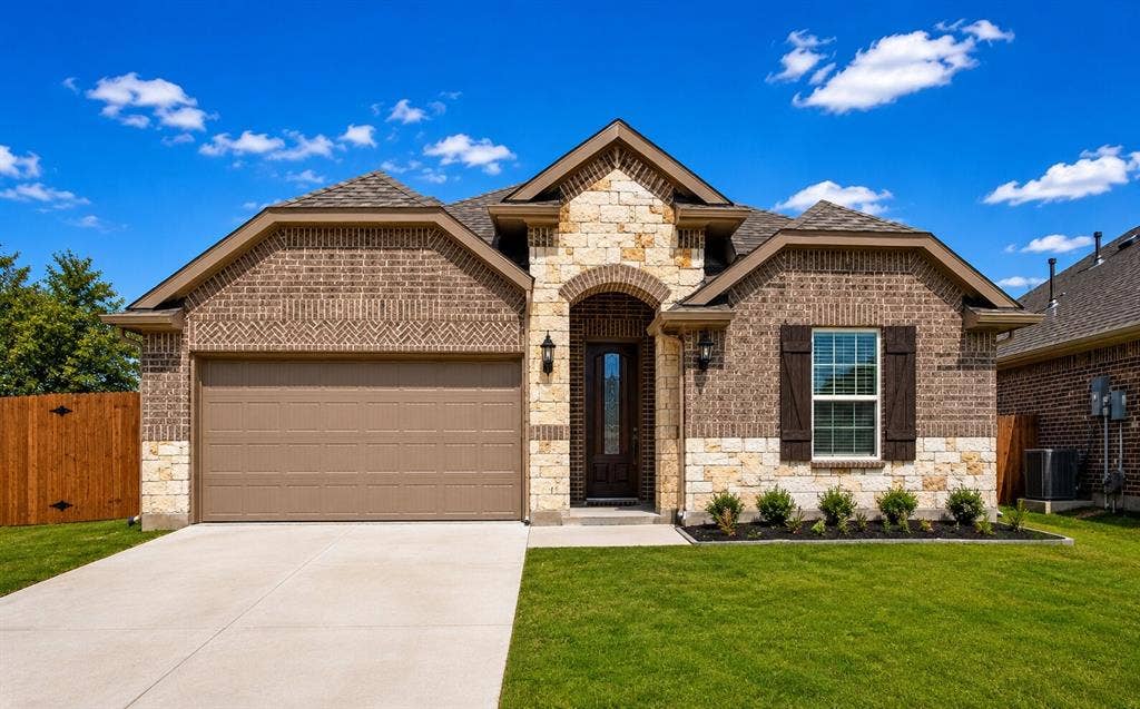 7204 Black Cherry Lane, McKinney, TX 75071 Brick and stone exterior featuring an arched entry, a two-car garage, and a manicured lawn