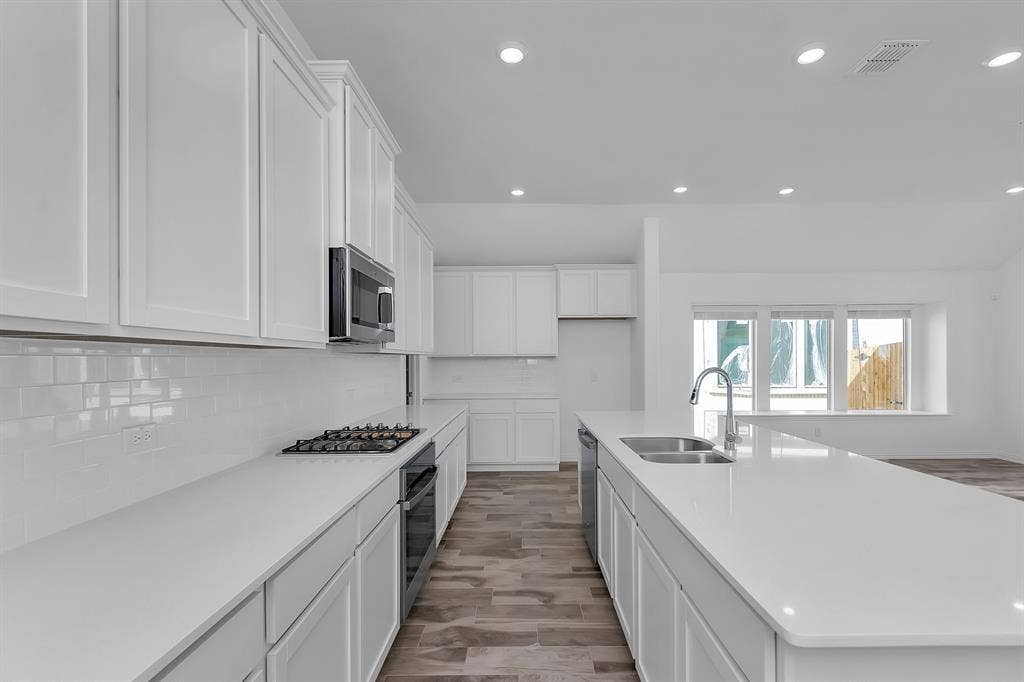 7204 Black Cherry Lane, McKinney, TX 75071 Kitchen with stainless steel appliances, recessed lighting, decorative backsplash, white cabinetry, and light countertops