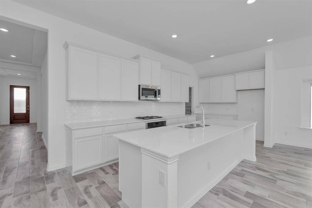 7204 Black Cherry Lane, McKinney, TX 75071 Kitchen featuring stainless steel appliances, white cabinetry, a center island with sink, tasteful backsplash, and recessed lighting