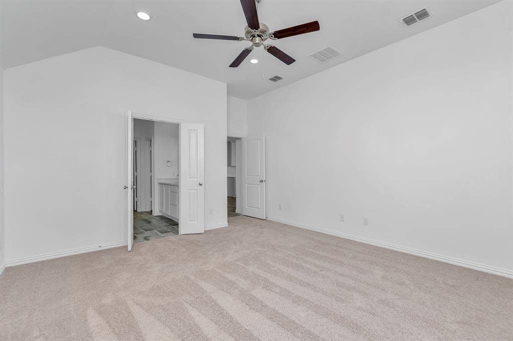 7204 Black Cherry Lane, McKinney, TX 75071 Unfurnished bedroom featuring light colored carpet, recessed lighting, lofted ceiling, connected bathroom, and ceiling fan