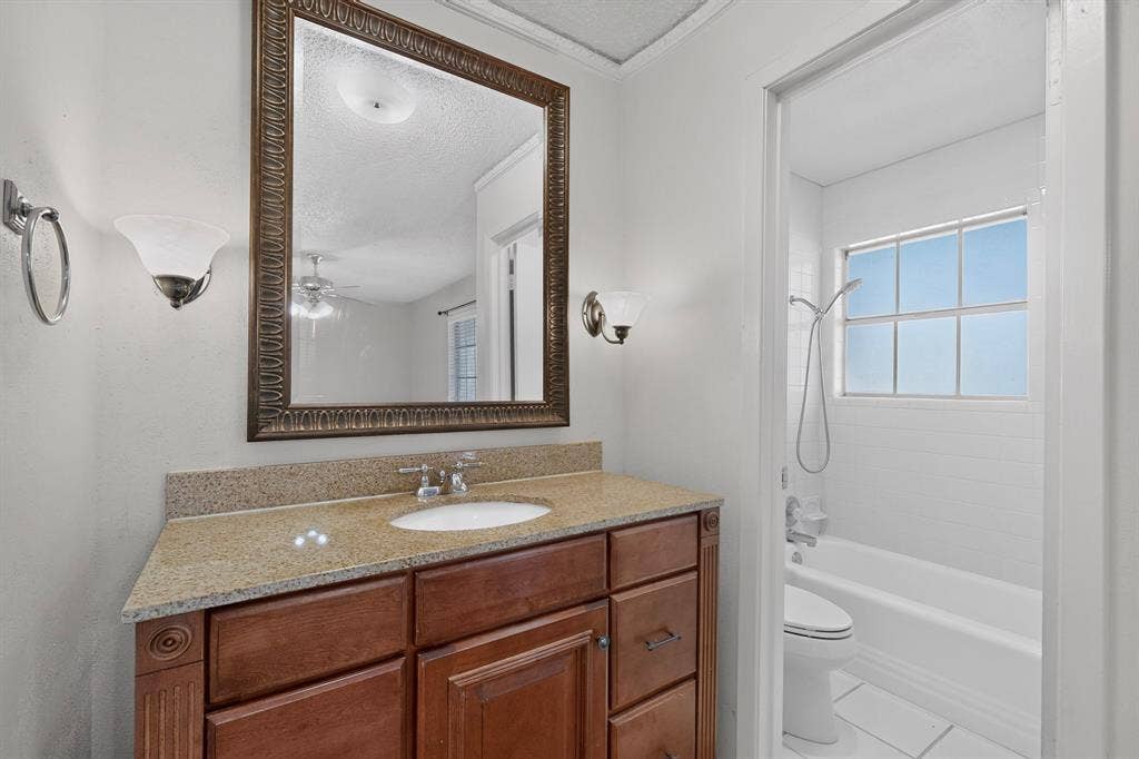 Wood-finish vanity with an integrated sink and light-toned countertop