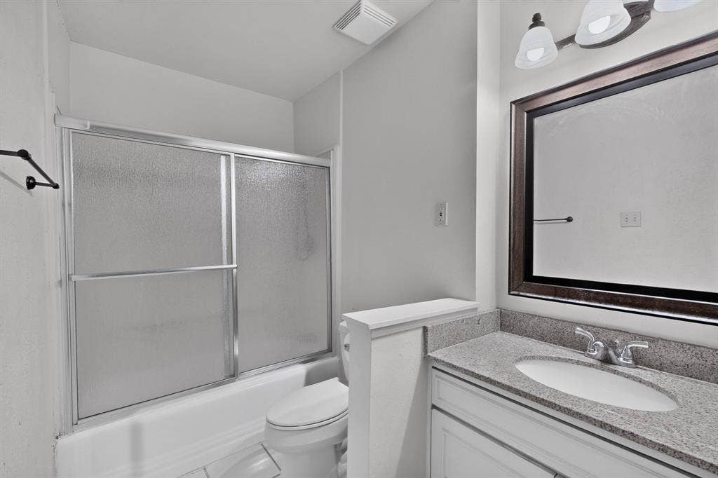 White vanity with a polished countertop, undermount sink, and chrome fixtures