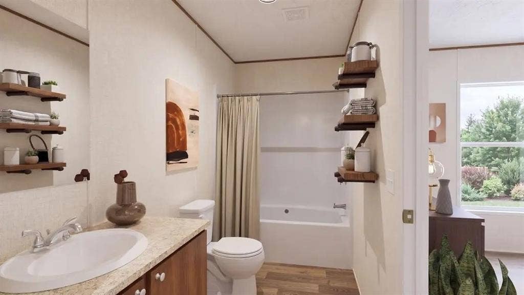 Bathroom featuring a vanity with a stone-finish countertop, oval integrated sink, wood-finish cabinetry, and wood-finish flooring, complemented by a tub-shower combination with a surround