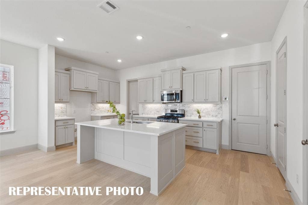 1401 Rooted Road, Frisco, TX 75033 The spacious kitchen island is the perfect gathering place for friends and family. REPRESENTATIVE PHOTO